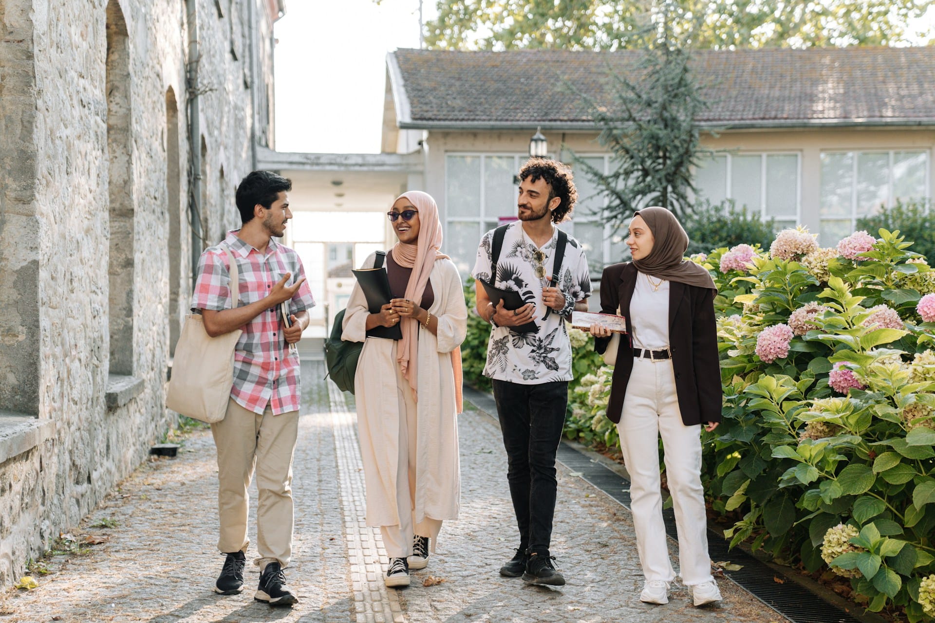 Expats in Türkiye walking by stone buildings and flowers, smiling and talking.